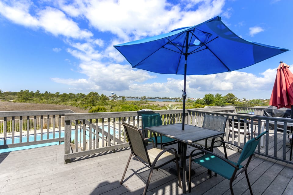 Private balcony with table, chairs and umbrella over the water