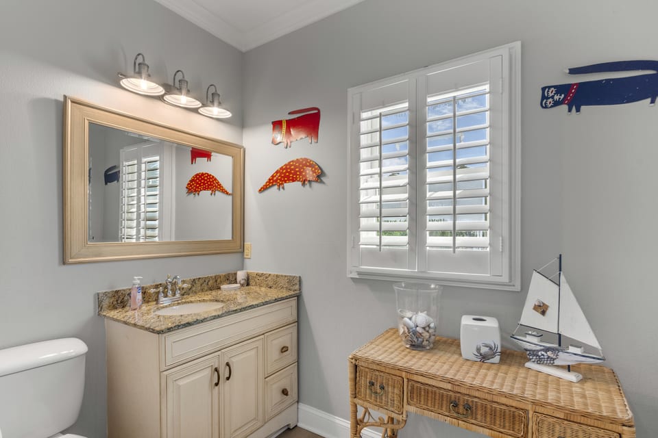 Bathroom with double vanity and coastal artwork