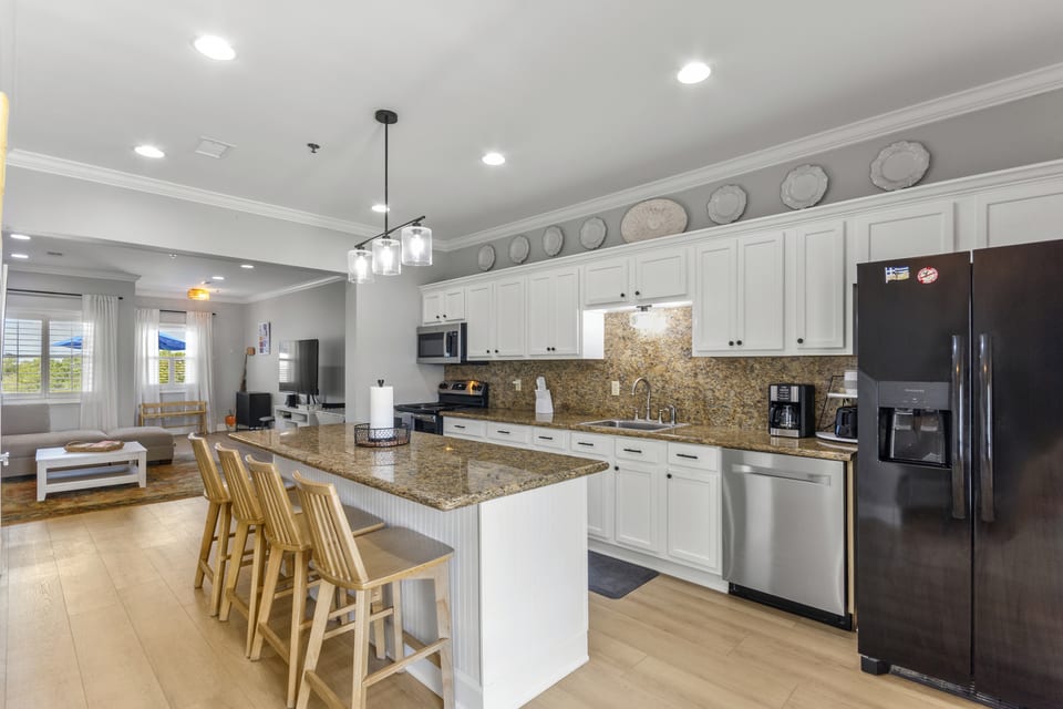 Granite island with bar stools, looking towards the balcony doors